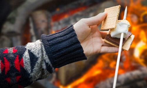 person making a smore by the campfire