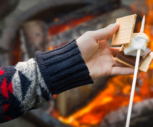 person making a smore by the campfire