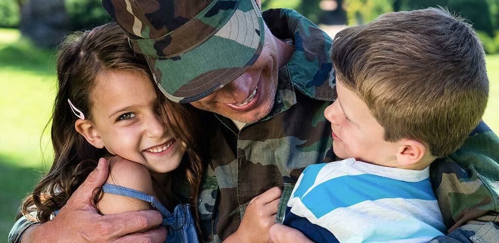 Man in the military hugging his children